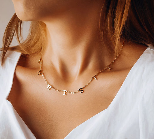 Dainty personalized gold name necklace styled with a strapless dress, one of the best necklaces for a strapless dress.